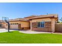 View of the garage and the side entrance, with artificial turf in front of the home at 20540 N 86Th Ln, Peoria, AZ 85382