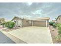 Angle view of an attached two-car garage and the front of the house, with a garden in front at 2101 S Meridian Rd # 99, Apache Junction, AZ 85120