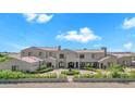 Elegant two-story home with a circular driveway, lush landscaping, and a private gated entrance at 2285 E Chandler Heights Rd, Chandler, AZ 85249