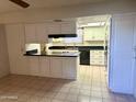 Open kitchen with white cabinets and black countertops with adjacent breakfast bar at 236 E Minton Dr, Tempe, AZ 85282