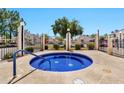 Relax in the community hot tub surrounded by a metal fence and well maintained landscaping at 2455 E Broadway Rd # 13, Mesa, AZ 85204