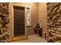 Inviting entryway with a decorative fountain, a 'Welcome' mat, and stone accents on the walls at 27654 N 125Th Dr, Peoria, AZ 85383