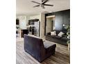 Open-concept living room with stylish furniture and adjacent kitchen, perfect for entertaining at 29908 W Monterey Dr, Buckeye, AZ 85396