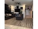 Living room features a flat screen TV, modern decor, and wood flooring at 29908 W Monterey Dr, Buckeye, AZ 85396