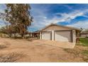 Detached two-car garage with white doors and ample parking space at 3137 W Baseline Rd, Laveen, AZ 85339
