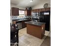 Kitchen with stainless steel appliances, dark wood cabinetry, and a central island at 37959 N Luke Ln, San Tan Valley, AZ 85140