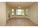 Bright living room featuring wood floors, ceiling fan, large windows, and balcony access at 435 W Rio Salado Pkwy # 210, Tempe, AZ 85281