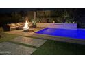 Backyard at night featuring a swimming pool and a comfortable seating area around a fire pit at 4457 E Fountain St, Mesa, AZ 85205