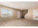 Bright living room with tile flooring, large window, and staircase access to upper level at 5254 N 42Nd Pkwy, Phoenix, AZ 85019