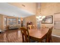 Dining area featuring a large wood table and chairs, chandelier, and hardwood floors at 5749 S 249Th Dr, Buckeye, AZ 85326