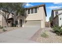 Two-story stucco home featuring a large driveway and well-kept landscaping at 9009 S 57Th Dr, Laveen, AZ 85339