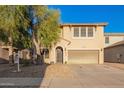 Charming two-story home with desert landscaping, large tree, and covered entryway at 9009 S 57Th Dr, Laveen, AZ 85339
