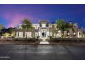 Striking modern home exterior featuring a grand entrance, mature trees, and manicured landscaping at twilight at 9735 E Kemper Way, Scottsdale, AZ 85255