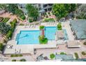 Aerial view of a community pool featuring lounge chairs, lush landscaping, and shade structures at 101 N 7Th St # 210, Phoenix, AZ 85034