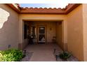 Covered front porch with tiled floor, security door and a small seating area at 15145 W Woodridge Dr, Surprise, AZ 85374