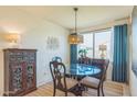 Elegant dining area with a round glass table, unique lighting, and stylish furniture at 18014 W Muirwood Dr, Goodyear, AZ 85338