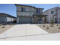 Two-story home featuring a gray exterior, a two car garage, and a neatly landscaped front yard at 18207 W Daley Ln, Surprise, AZ 85387
