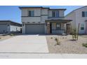 Two-story home featuring a gray exterior, a two car garage, and a neatly landscaped front yard at 18207 W Daley Ln, Surprise, AZ 85387
