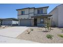Two-story home featuring a gray exterior, a two car garage, and a neatly landscaped front yard at 18207 W Daley Ln, Surprise, AZ 85387
