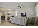 Spacious living room with a ceiling fan, TV, and view of dining area with fireplace at 1935 W Periwinkle Way, Chandler, AZ 85248