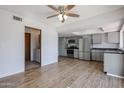 Open-concept living space showcasing the updated kitchen and light wood floors, with laundry room entrance at 2605 N Pleasant Dr, Chandler, AZ 85225