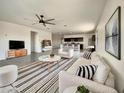 Bright living room with modern decor featuring stylish furnishings, a ceiling fan, and an open floor plan at 35972 W Seville Dr, Maricopa, AZ 85138