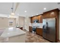 Open concept kitchen design with stainless steel appliances, a breakfast bar, and hardwood cabinetry at 3747 E Harmony Ave, Mesa, AZ 85206