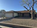 A well-maintained single-story brick home with a two-car garage, complemented by desert landscaping at 409 W Ross Ave, Phoenix, AZ 85027