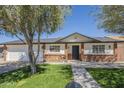 Inviting home with a well-kept lawn, complemented by a classic brick and white facade at 4646 E Contessa St, Mesa, AZ 85205