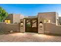 Gated entrance showing the exterior of a Southwestern home with desert landscaping at 6643 E El Sendero Rd, Carefree, AZ 85377