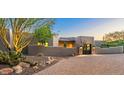 Exterior view of home with desert landscaping, and a gated entrance along a paved driveway at 6643 E El Sendero Rd, Carefree, AZ 85377