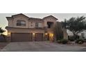 Beautiful two-story home with a three-car garage, desert landscaping and exterior lighting at 10922 N 153Rd Ln, Surprise, AZ 85379