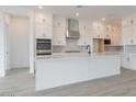 Modern kitchen with white cabinets, stainless steel appliances, a stylish backsplash, and a large island at 1246 E Penedes Dr, Gilbert, AZ 85298