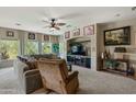 Comfortable living room includes soft carpet, sectional sofa, and entertainment center with leafy decor at 16525 E Avenue Of The Fountains Ave # 201, Fountain Hills, AZ 85268