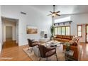 Bright living room with high ceilings, a cozy fireplace, hardwood floors, and comfortable leather furniture at 17741 N Desert Flower Trl, Surprise, AZ 85374