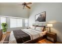 Serene main bedroom features a vaulted ceiling, a large picture window, and warm, inviting decor at 17741 N Desert Flower Trl, Surprise, AZ 85374