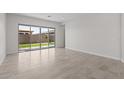 Bright living area with neutral tile flooring and sliding glass doors that provide access to the backyard at 19323 W San Juan Ave, Litchfield Park, AZ 85340