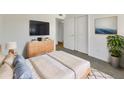 This staged bedroom features wood-look floors, a dresser, closet, and a serene ambiance at 2224 E Glade Ave, Mesa, AZ 85204