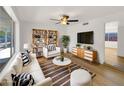 Bright living room features modern furnishings, a ceiling fan, large windows, and stylish decor at 2224 E Glade Ave, Mesa, AZ 85204