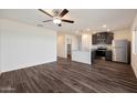 Spacious living area with a ceiling fan flows into a kitchen with stainless steel appliances, providing an open layout at 626 W Pintail Dr, Casa Grande, AZ 85122