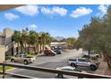 Balcony view overlooking a parking lot with desert landscaping, palm trees, and mountains in the background at 7009 E Acoma, Lot #2060 Dr # 2060, Scottsdale, AZ 85254