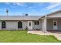 Inviting front entrance with a white door, brick walkway, desert landscaping and an attached carport at 9716 N 55Th Ave, Glendale, AZ 85302