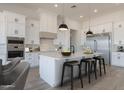 Bright eat-in kitchen with white cabinetry, stainless steel appliances, and large island at 13952 E Barwick Dr, Scottsdale, AZ 85262