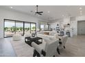 Open-concept living room featuring modern furniture, a ceiling fan, and view to the backyard at 13952 E Barwick Dr, Scottsdale, AZ 85262