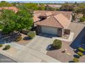 Front exterior of home with mature trees, desert landscaping, and a two-car garage at 2381 E Firerock Dr, Casa Grande, AZ 85194