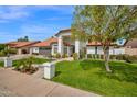 Beautiful home with a manicured lawn, vibrant landscaping, and a welcoming entrance at 2924 E Mallory St, Mesa, AZ 85213