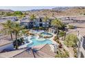 Stunning aerial view showcasing a resort-style pool, palm trees, and desert mountain views at 3236 E Chandler Blvd # 3078, Phoenix, AZ 85048