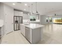 Open kitchen with stainless steel appliances, center island with breakfast bar, and seamless flow to living spaces at 6247 W Georgetown Way, Florence, AZ 85132