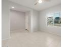 Open living room with tiled floors, neutral color palette, and large window for natural light at 6247 W Georgetown Way, Florence, AZ 85132