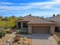 Beautiful single-story home with a tile roof, desert landscaping, and two-car garage at 6827 E Eagle Feather Rd, Scottsdale, AZ 85266